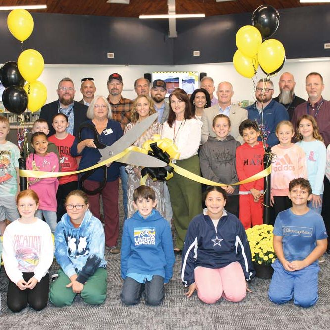 NEW LIBRARY — On October 22, Sugar Loaf School hosted a ribbon cutting ceremony for their new media center. Fourth graders in Mrs. Natalie Millsaps’ fourth grade class enjoyed the media center after the ribbon cutting. Pictured, left to right: front row – Emmie Broadway, Pasleigh Hill, Paige Reedy, Sawyer Dyson, Maddison Parsons, and Josiah Thomas. Second row – Grayson Keller, Teagan Clark, Kaleigha Blount, Jake James, Rachel Dagenhart, Media Coordinator Jennifer Robertson, Principal Dawn Leary, Data Manager Lisa Warren, Bentley Holmes, Jaxon Lopez, London Triplett, Ellie Morrison, and Calli Huffman. Third row – School Board Vice Chairman Josh Dagenhart, County Commissioner Marty Pennell, Roger Bedsal from JM Cope Construction, County Commissioner Ronnie Reese, Coleman Clark from JM Cope Construction, Nichol Lancaster and Scott McHugh from Custom Educational Furnishings, Superintendent Dr. Bill Griffin, former Sugar Loaf Principal Joe Mabry, School Board Chairman Matthew Reese, School Board Member Shannon Oxentine, and ACS Maintenance Director Bryan Davis. 