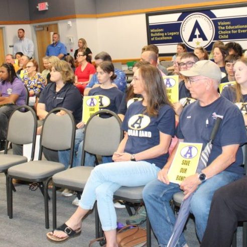 BAND SUPPORT -- Parents, students, band boosters, teachers, and administrators came to the Board of Education meeting June 8, 2026, to support the band program at Alexander Central High School. Many were holding yellow signs that said, “Save our Band.”